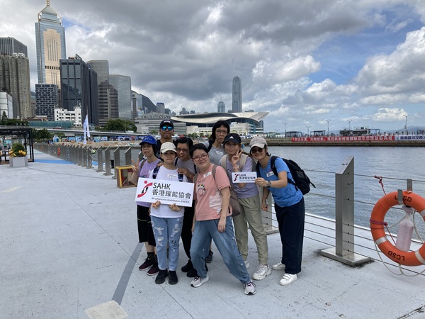 舍友及職員在維港美景前留影。