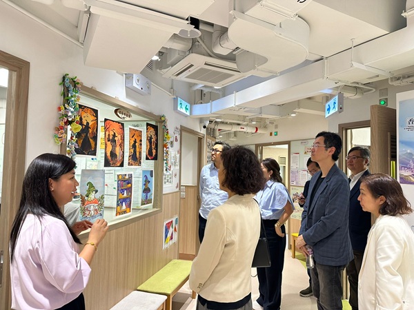 一眾視察團員細心觀賞石圍角家長資源中心的畫作。