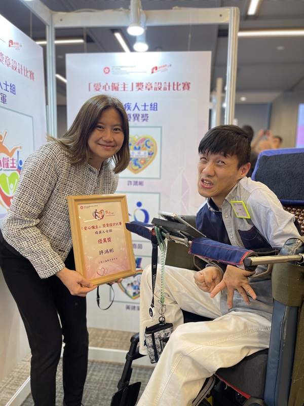 康復專員姜梁詠怡女士, JP（左）對許鴻彬先生的作品大表讚賞，並鼓勵他繼續努力。